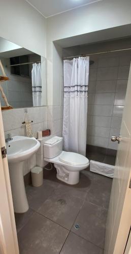 a bathroom with a white toilet and a sink at Sai in Lima