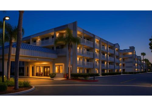 a large building with palm trees in front of it at Motel 6-Anaheim, CA - Maingate in Anaheim