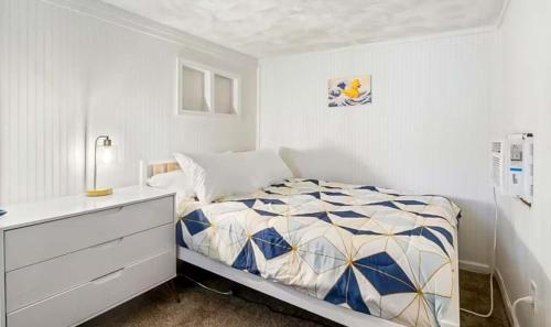 a white bedroom with a bed and a dresser at The Rubber Duck in Gravois Mills