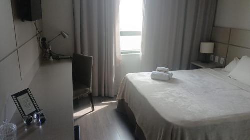 a hotel room with a bed and a window at Flat Encantador in Três Rios