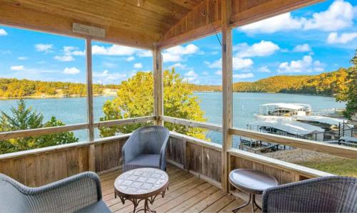 a porch with chairs and a view of a boat at Amber Waters Hideaway in Camdenton