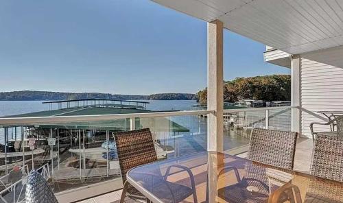 a balcony with chairs and a boat on the water at Waters Edge in Lake Ozark