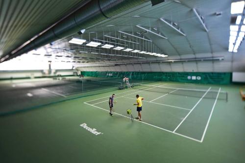 two men standing on a tennis court at Hotel Włókniarz in Pabianice