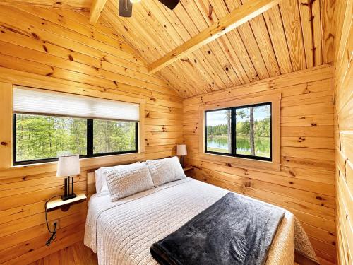 a bedroom with a bed in a wooden cabin at Oceanfront Sunset View Cabin in Milbridge
