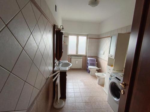 a bathroom with a toilet sink and a washing machine at Sara's Home Vetralla in Vetralla