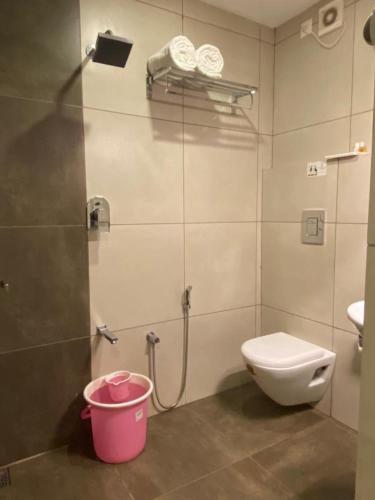 a bathroom with a shower with a toilet and a bucket at THE PORCH INN in Wayanad