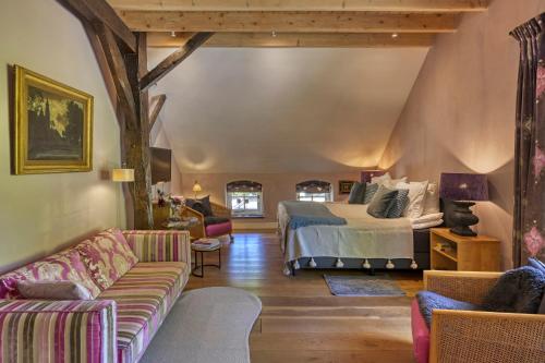 a bedroom with a bed and a couch at Bedandbreakfast De Vallei in Heelsum