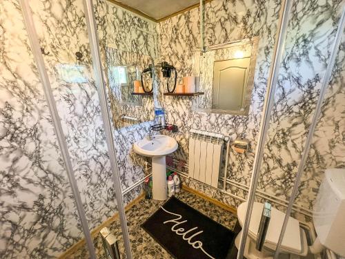 ein Badezimmer mit Toilette und Waschbecken in der Unterkunft Cabana IBU in Bumbueşti