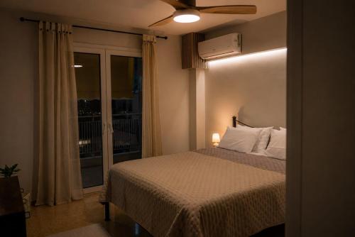 a bedroom with a bed with a window and a ceiling fan at VERADO by A&D Properties in Porto Rafti