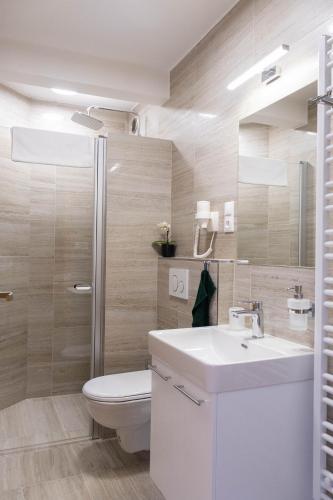 a bathroom with a toilet and a sink and a shower at Penzion Rališka in Horní Bečva