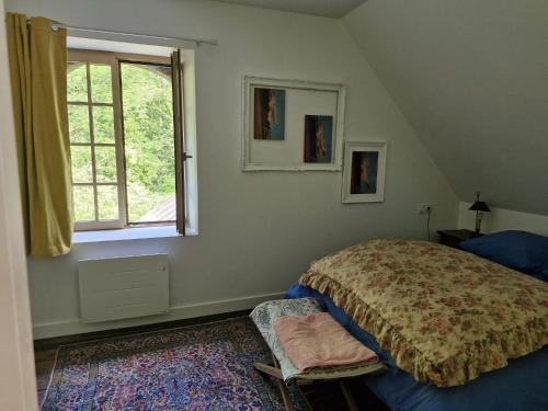 a bedroom with a bed and a window at La Chaumière in Fréhel