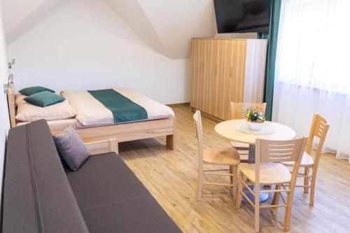 a small room with a bed and a table and a dining room at Penzion Rališka in Horní Bečva