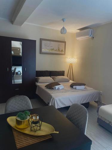 a hotel room with two beds and a table and chairs at Apartments Marash in Kotor