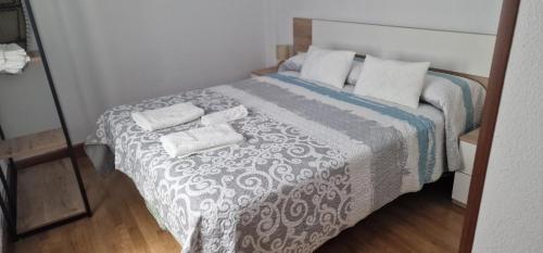 a bedroom with a bed with two towels on it at Vivienda Turistica IBAMA2 in Ciudad-Rodrigo