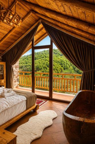 a bedroom with a bed and a large window at Villa Lugina e Kuajve Bulqize in Bulqizë