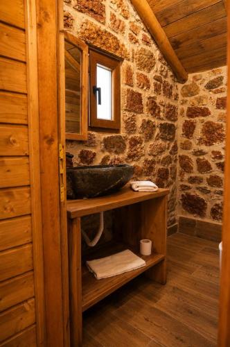a bathroom with a sink and a stone wall at Villa Lugina e Kuajve Bulqize in Bulqizë