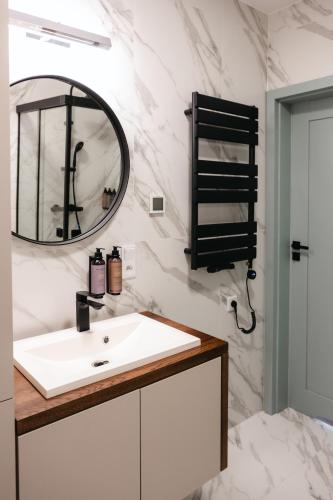 a bathroom with a sink and a mirror at Nowy Sącz Apartamenty in Nowy Sącz