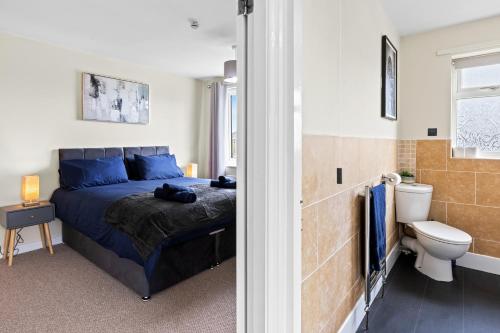 a bedroom with a bed and a bathroom with a toilet at Great Sutton House Perfect for Contractors in Sutton