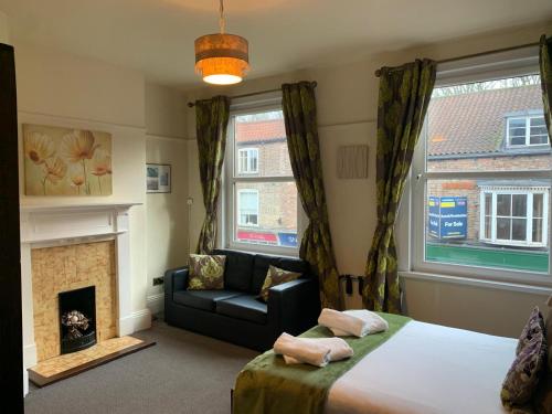 a bedroom with a bed and a couch and a fireplace at Gillygate Guest House in York