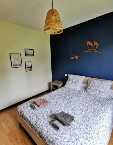 a bedroom with a bed with a blue wall at Calme entre pins et océan in Onesse-et-Laharie