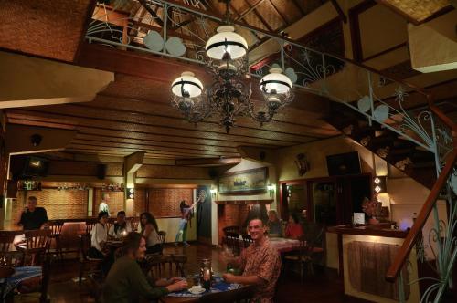 um grupo de pessoas sentadas em mesas em um restaurante em Strawberry Hill Hotel & Restaurant em Bedugul