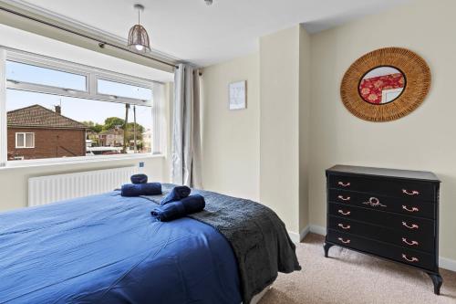 a bedroom with a blue bed and a window at Great Sutton House Perfect for Contractors in Sutton
