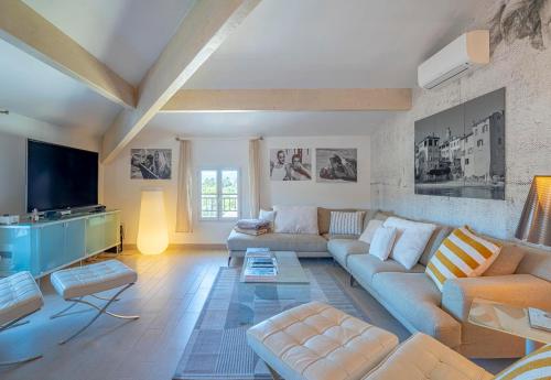 a living room with a couch and a tv at Appartement DELICE A in Saint-Tropez