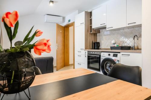 a kitchen with a table with a vase of flowers at Apartmaji Tinta in Kanal