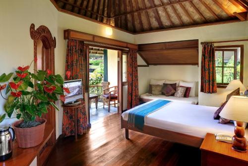 a bedroom with a bed and a television in a room at Strawberry Hill Hotel & Restaurant in Bedugul