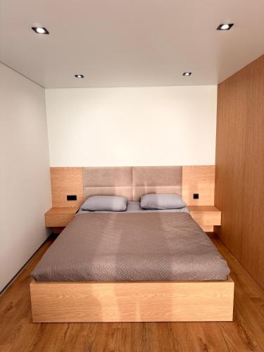 a bedroom with a large bed with a wooden headboard at NV Apartments 2 in Volodymyr-Volynskyi