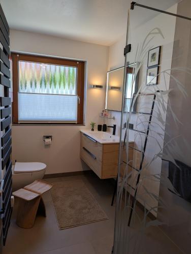 a bathroom with a sink and a toilet and a window at Kunst am Marktplatz in Niederwerrn