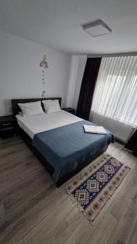 a bedroom with a bed with a blue comforter at Casa AVA 2 Mai in 2 Mai