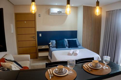 a hotel room with a bed and a table with chairs at Studio premium aconchegante vista mar in São Luís
