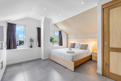 a bedroom with a bed and two windows at Art Hotel in Kralendijk