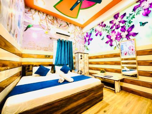 a bedroom with a bed with purple flowers on the wall at K D Dham Hotel- Near Prem Mandir & Iskcon Temple Vrindavan in Vrindāvan
