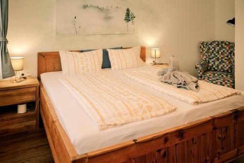 a large bed in a room with a chair at Kunstwerk AppARTement in Sankt Michael im Lungau