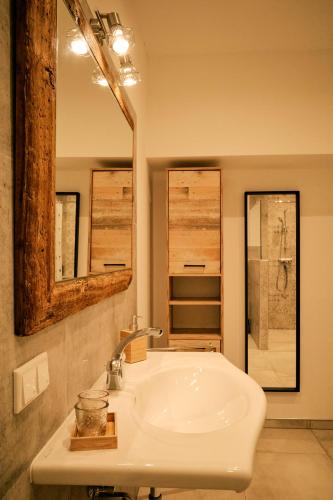 a bathroom with a white sink and a mirror at Kunstwerk AppARTement in Sankt Michael im Lungau