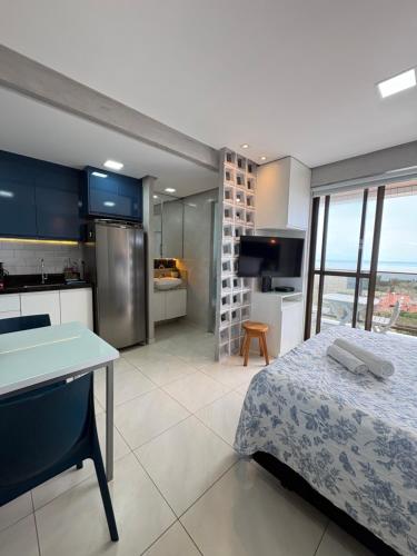 a bedroom with a bed and a kitchen with a view at STUDIO Mar azul 1206 in São Luís