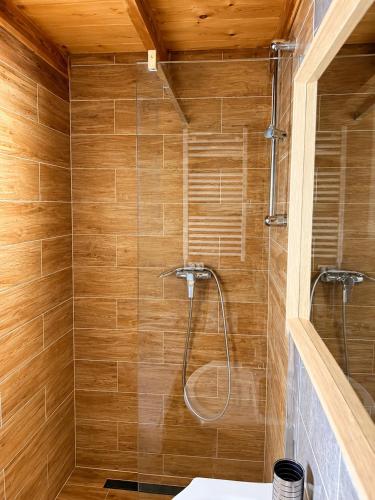 a bathroom with a shower with wooden walls at Chaty Jak Dawniej 787-330-207 in Wołkowyja