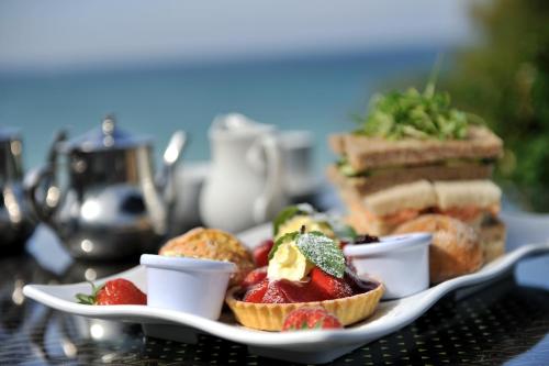 a plate of food with fruit and bread on a table at Carbis Bay and Spa Hotel in St Ives