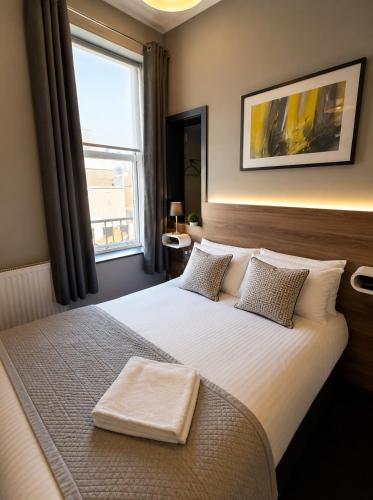 a bedroom with a large white bed with a window at The Bromley's in Great Yarmouth