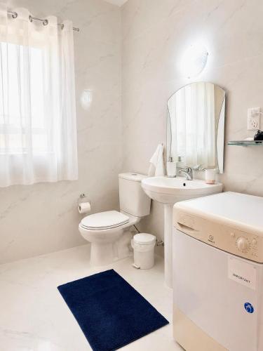 a white bathroom with a toilet sink and a mirror at Seaview luxury flat 4 bedrooms in Sliema