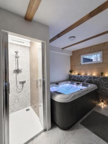 a large bathroom with a tub and a shower at Guesthouse Mreznica- Mreznicka Idila resort in Galović-Selo
