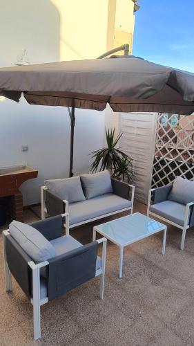 a patio with couches and a table and an umbrella at Archimede29 in Syracuse