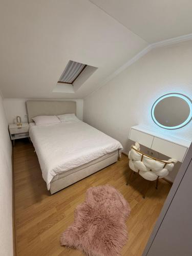 a bedroom with a bed and a mirror and a rug at Apartman Maja in Prijedor