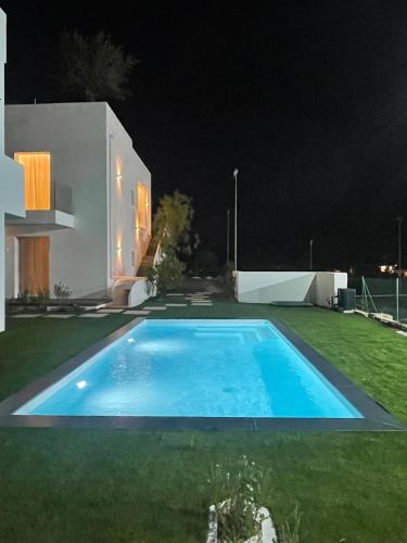 a swimming pool in the yard of a house at night at Like at Home - Boutique A6 Sea view, Private Terrace & Pool in Palau