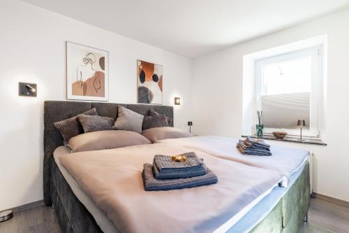 a large bed in a white room with a large bed at Eifel Quartier im Herzen von Mendig in Mendig