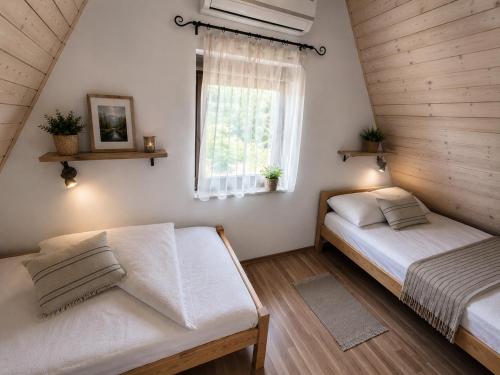 two beds in a room with a window at Guesthouse Mreznica- Mreznicka Idila resort in Galović-Selo