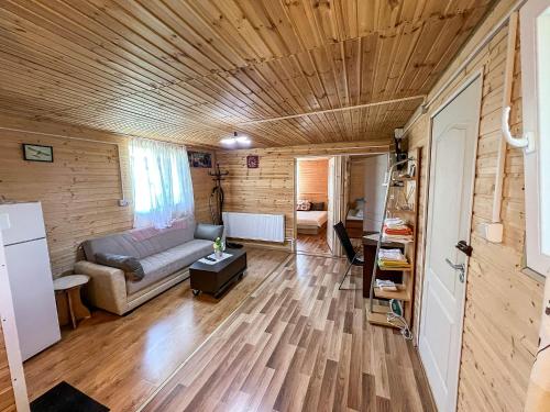ein Wohnzimmer mit Sofa und Holzdecke in der Unterkunft Cabana IBU in Bumbueşti