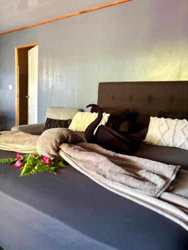 a bed with two blankets and flowers on it at Bora Bora Wonderful Lodge in Bora Bora
